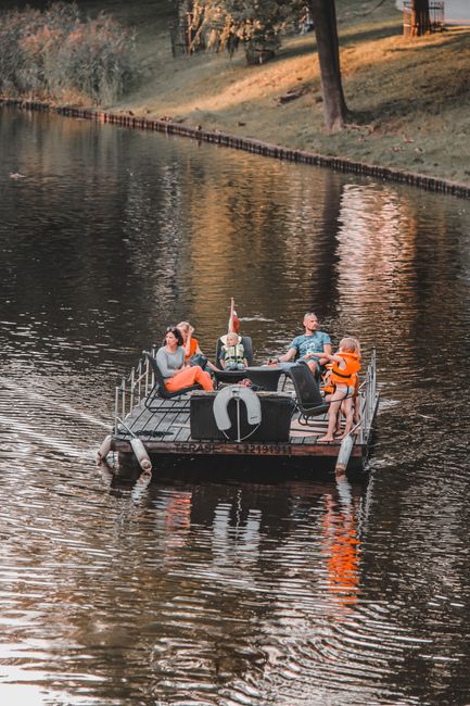 A family enjoys a relaxing day on a floating platform in a Riga lake.