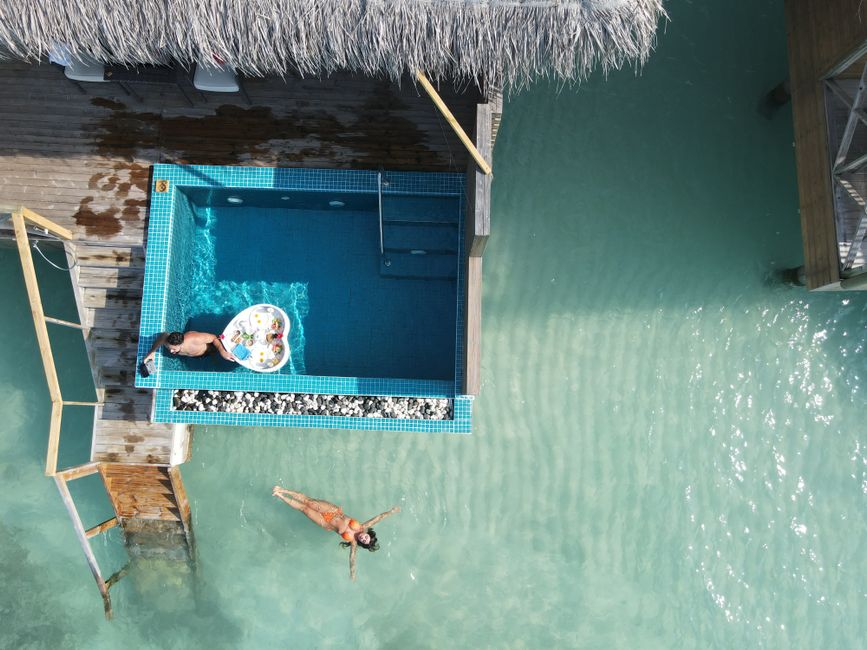 Aerial view of a resort with a pool and people relaxing, enjoying leisure time.