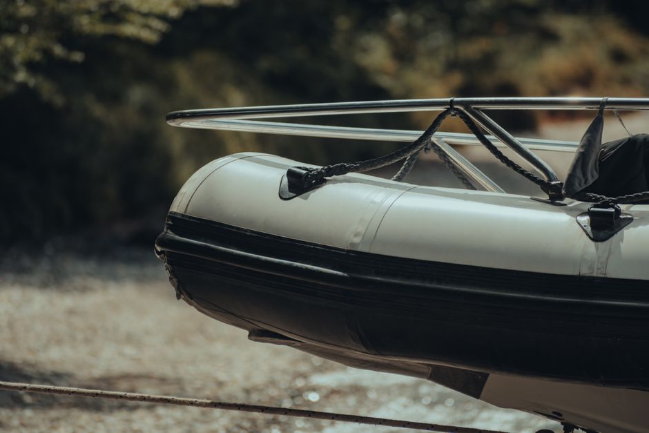 A detailed look at a modern inflatable boat tied at a riverbank.